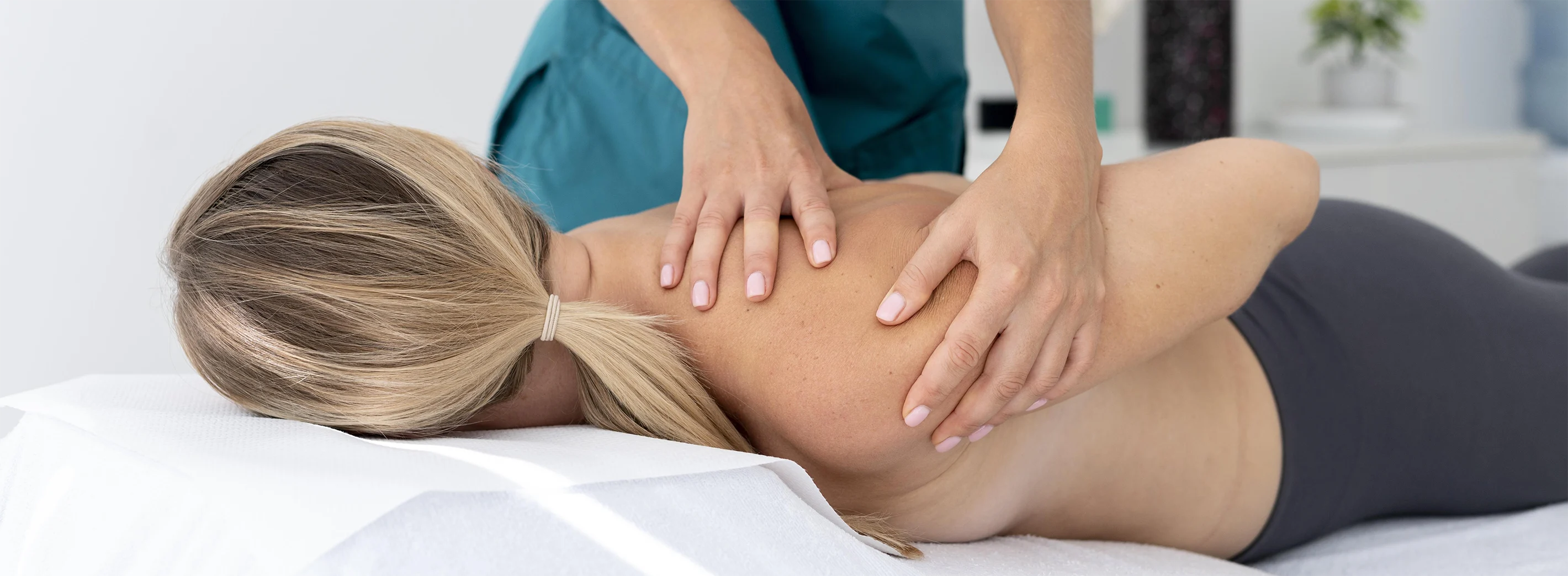 profesional fisioterapeuta aplica fisioterapia y rehabilitación de hombro a joven mujer en clínica